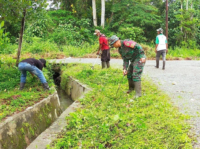 Ciptakan Lingkungan Bersih, Babinsa Koramil 1710-03/Kuala Kencana Kerja Bakti Bersihkan Jalan
